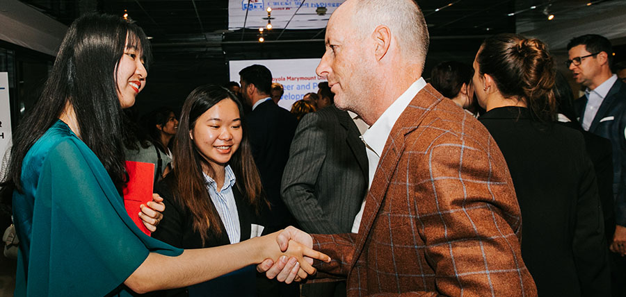 a student shaking hands with an alumni